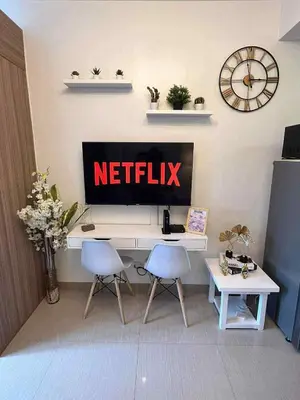 a television sitting on top of a desk with two chairs at Erin's Place in Manila