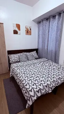 a bedroom with a bed with a black and white comforter at Vista Shaw Residences in Manila