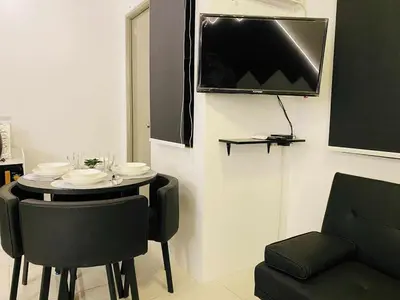 a dining room with a table and a tv on the wall at Stay De Lax in Santa Rosa