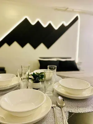 a table with white plates and glasses and spoons at Stay De Lax in Santa Rosa