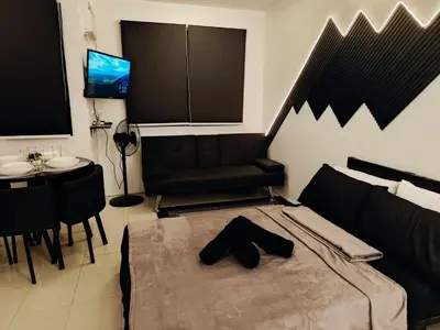 a bedroom with a bed and a table and a television at Stay De Lax in Santa Rosa