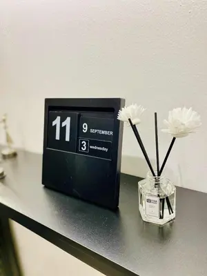 a clock sitting on a counter with flowers in a vase at Stay De Lax in Santa Rosa