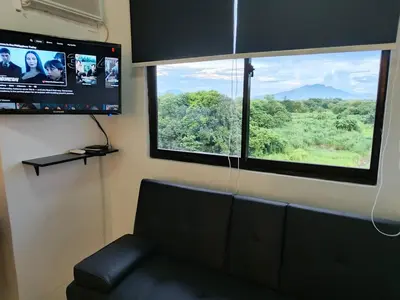 a living room with a couch and a large window at Stay De Lax in Santa Rosa