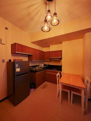 a kitchen with a table and a black refrigerator at Levi & Moon's Chill with beautiful view in Manila