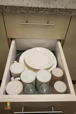 a drawer filled with plates and bowls in a cabinet at Pause Point - Standford 3 Suites in Silang