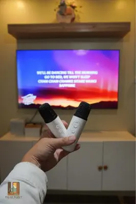 a person holding two wii controllers in front of a tv at Pause Point - Standford 3 Suites in Silang