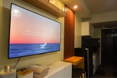 a large flat screen tv hanging on a wall at Pause Point - Standford 3 Suites in Silang