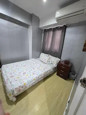 a small bedroom with a bed and a night stand at Condo 2 bedroom victoria de makati in Manila