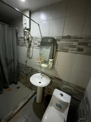 a bathroom with a toilet and a sink and a mirror at Condo 2 bedroom victoria de makati in Manila