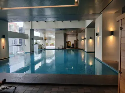 a large swimming pool in a building at Condo 2 bedroom victoria de makati in Manila