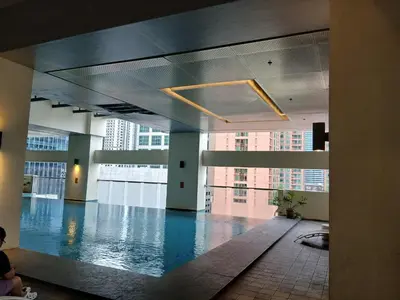 a large swimming pool in a building with buildings at Condo 2 bedroom victoria de makati in Manila