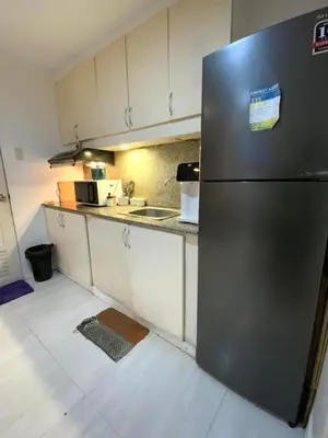 a kitchen with a stainless steel refrigerator in a room at Condo 2 bedroom victoria de makati in Manila