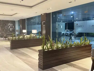 a lobby with a row of potted plants at Levi & Moon's Home in Manila