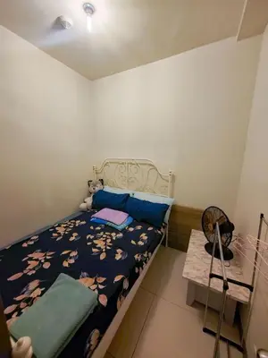 a small bedroom with a bed and a table at Levi & Moon's Home in Manila