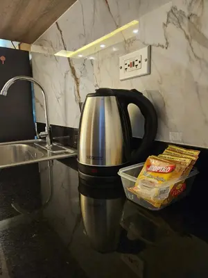 a coffee pot sitting on a counter next to a sink at Cozy Escape Shore 2 Tower 3 -MOA - Pasay- 2 Beds in Manila