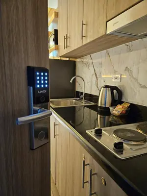 a kitchen with a sink and a stove top oven at Cozy Escape Shore 2 Tower 3 -MOA - Pasay- 2 Beds in Manila