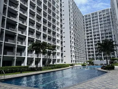 a large apartment building with a swimming pool in front at Cozy Escape Shore 2 Tower 3 -MOA - Pasay- 2 Beds in Manila