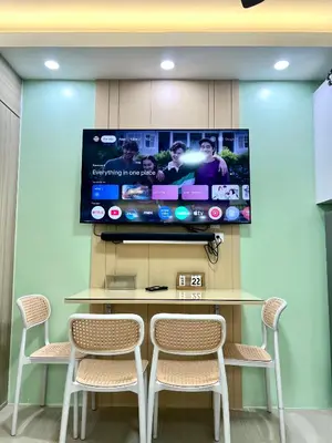 a tv on a wall with a table and chairs at Condo Room Apartment in Mall of Asia Complex Pasay City - Near Airport in Manila
