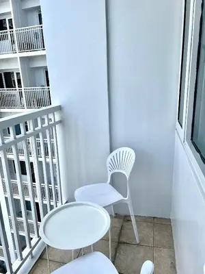 a white chair and a table on a balcony at Condo Room Apartment in Mall of Asia Complex Pasay City - Near Airport in Manila