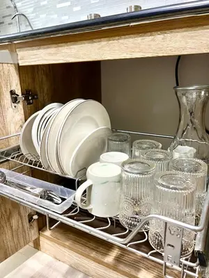 a dish drying rack with plates and dishes in a drawer at Condo Room Apartment in Mall of Asia Complex Pasay City - Near Airport in Manila