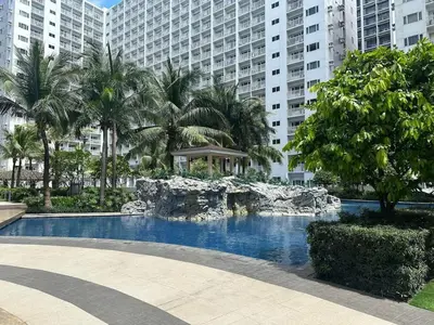 a swimming pool in front of a large building at Condo Room Apartment in Mall of Asia Complex Pasay City - Near Airport in Manila