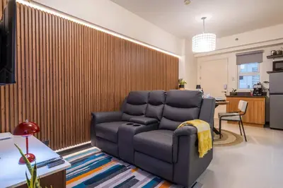 a living room with a couch in front of a wall at Prime 2-BR apartment near major business districts in Manila