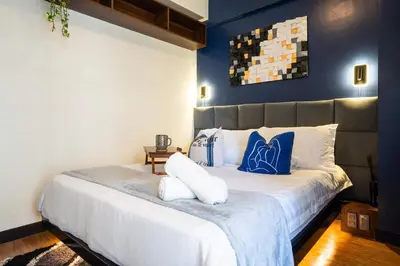 a bedroom with a large bed with blue walls at Prime 2-BR apartment near major business districts in Manila
