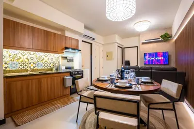 a kitchen and dining room with a table and chairs at Prime 2-BR apartment near major business districts in Manila
