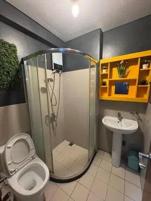a bathroom with a shower and a toilet and a sink at The Beacon Makati in Manila