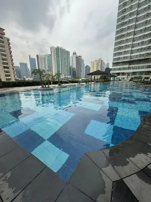 a large swimming pool in a city with tall buildings at The Beacon Makati in Manila