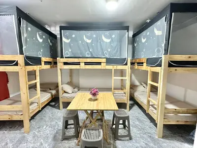 a room with three bunk beds and a table at W Tramo Residences in Manila