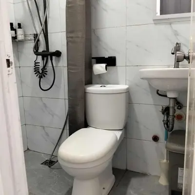 a bathroom with a white toilet and a sink at W Tramo Residences in Manila