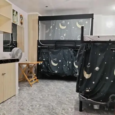 a bedroom with a bed with a moon and stars backdrop at W Tramo Residences in Manila