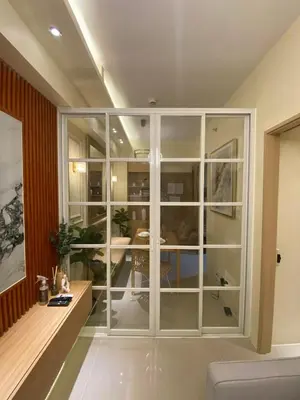 a living room with a large glass wall at Hallin Bay Suites Modern 1BR with balcony in Manila