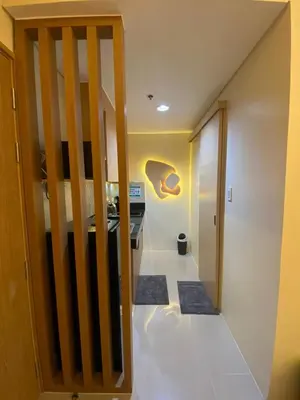 a hallway with a stairway leading to a room with a kitchen at Hallin Bay Suites Modern 1BR with balcony in Manila