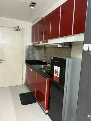 a kitchen with red cabinets and a stainless steel refrigerator at Sea Residences SM Mall of Asia Cj in Manila