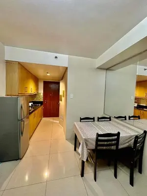 a kitchen with a table and chairs and a refrigerator at Sea Residences SM Mall of Asia Cj in Manila