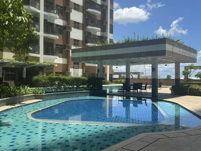 a swimming pool with a gazebo in front of a building at Radiance Manila bay 2 br & 3 bath in Manila