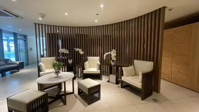 a living room with chairs and a table and a couch at 2 bedroom Luxury Condo in Eastwood with Scenic City view, unli wifi and netflix in Manila