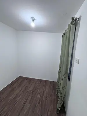 an empty room with a curtain and a wooden floor at A peace and quiet home away from your home in Calamba