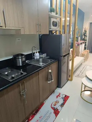 a kitchen with a sink and a refrigerator at SkyShore Suites in Manila