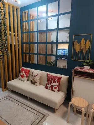 a living room with a couch with pillows on it at SkyShore Suites in Manila