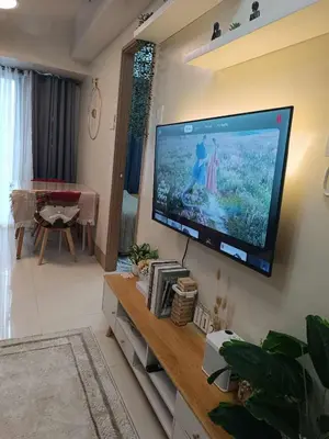 a living room with a large flat screen tv on the wall at SkyShore Suites in Manila