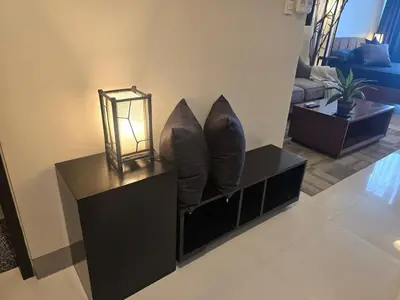 a living room with a lamp and two pillows at Very Cosy One Uptown near Grand Hyatt Hotel BGC Uptown Mall and St Lukes Medical Center in Manila