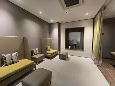 a waiting room with couches and chairs and a window at Very Cosy One Uptown near Grand Hyatt Hotel BGC Uptown Mall and St Lukes Medical Center in Manila