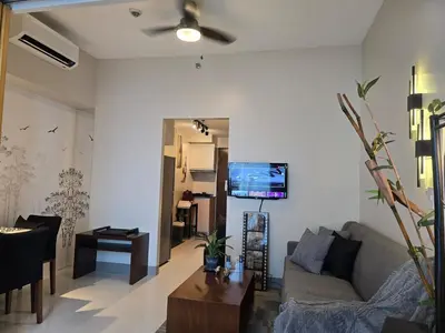 a living room with a couch and a table at Very Cosy One Uptown near Grand Hyatt Hotel BGC Uptown Mall and St Lukes Medical Center in Manila