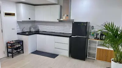 a kitchen with a black refrigerator and white cabinets at L A Azure staycation in Manila