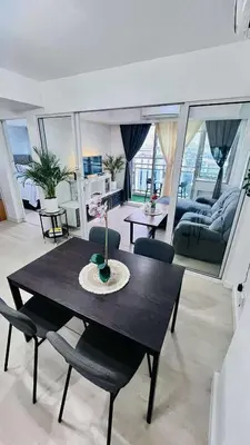 a living room with a black table and chairs at L A Azure staycation in Manila
