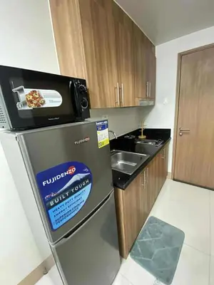 a small kitchen with a pizza on top of a refrigerator at Staycation Delight by R2CK in Manila