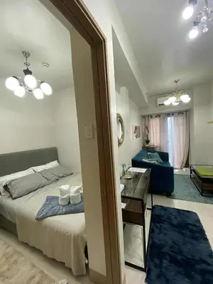 a bedroom with a bed and a desk and a mirror at Staycation Delight by R2CK in Manila